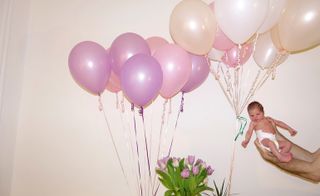 newborn baby with balloons