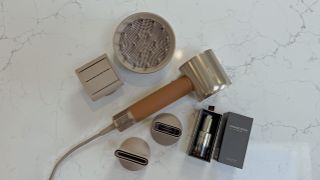 Dreame Miracle Pro laid out with all included attachments and Boca essence bottle on a quartz surface