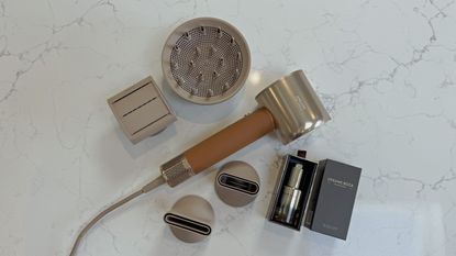 Dreame Miracle Pro laid out with all included attachments and Boca essence bottle on a quartz surface