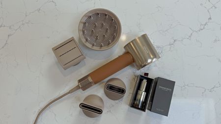 Dreame Miracle Pro laid out with all included attachments and Boca essence bottle on a quartz surface