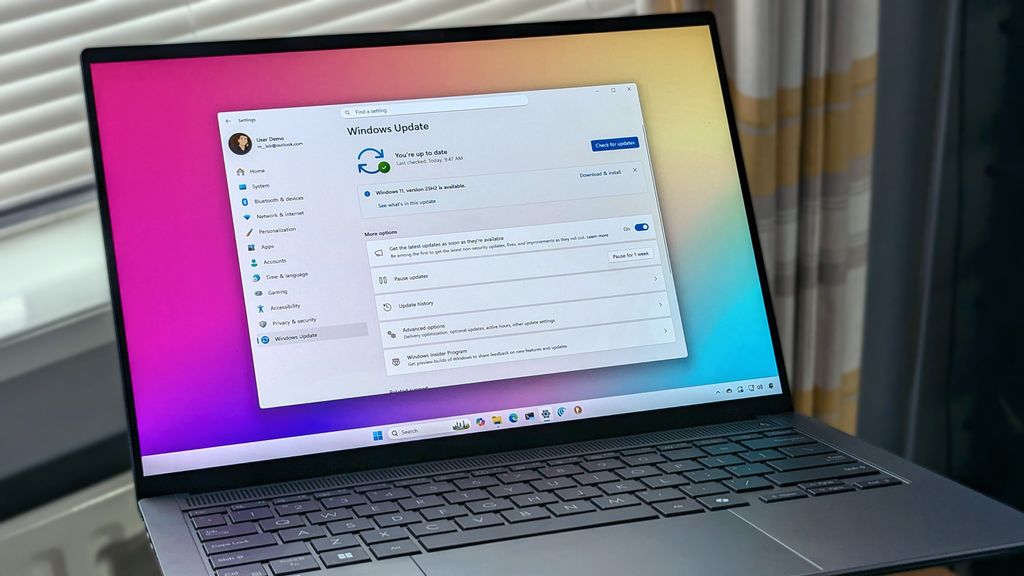 ASUS Zenbook 14 OLED laptop displaying Windows 11 with Windows Update screen