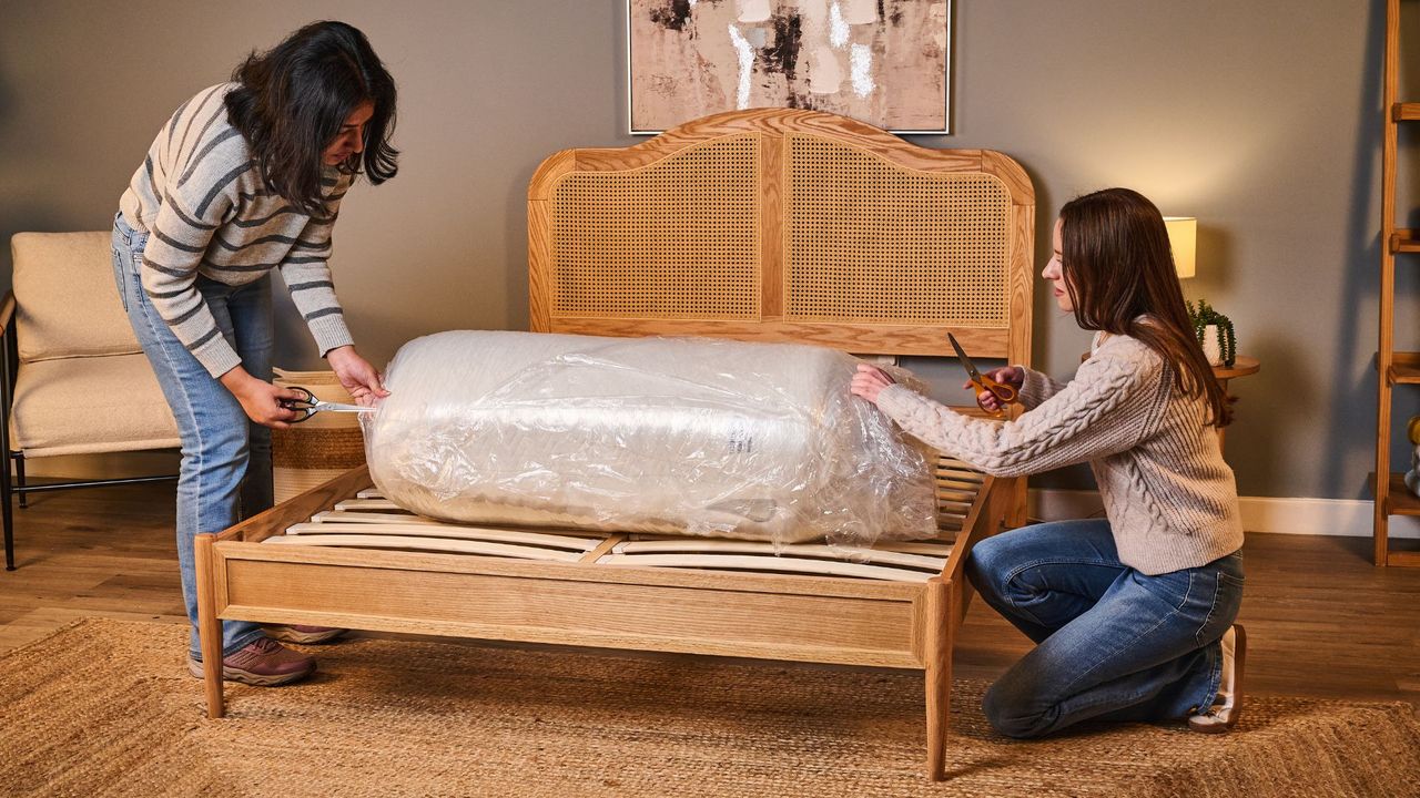 Two testers cut open the rolled-up Leesa Legend Hybrid Mattress