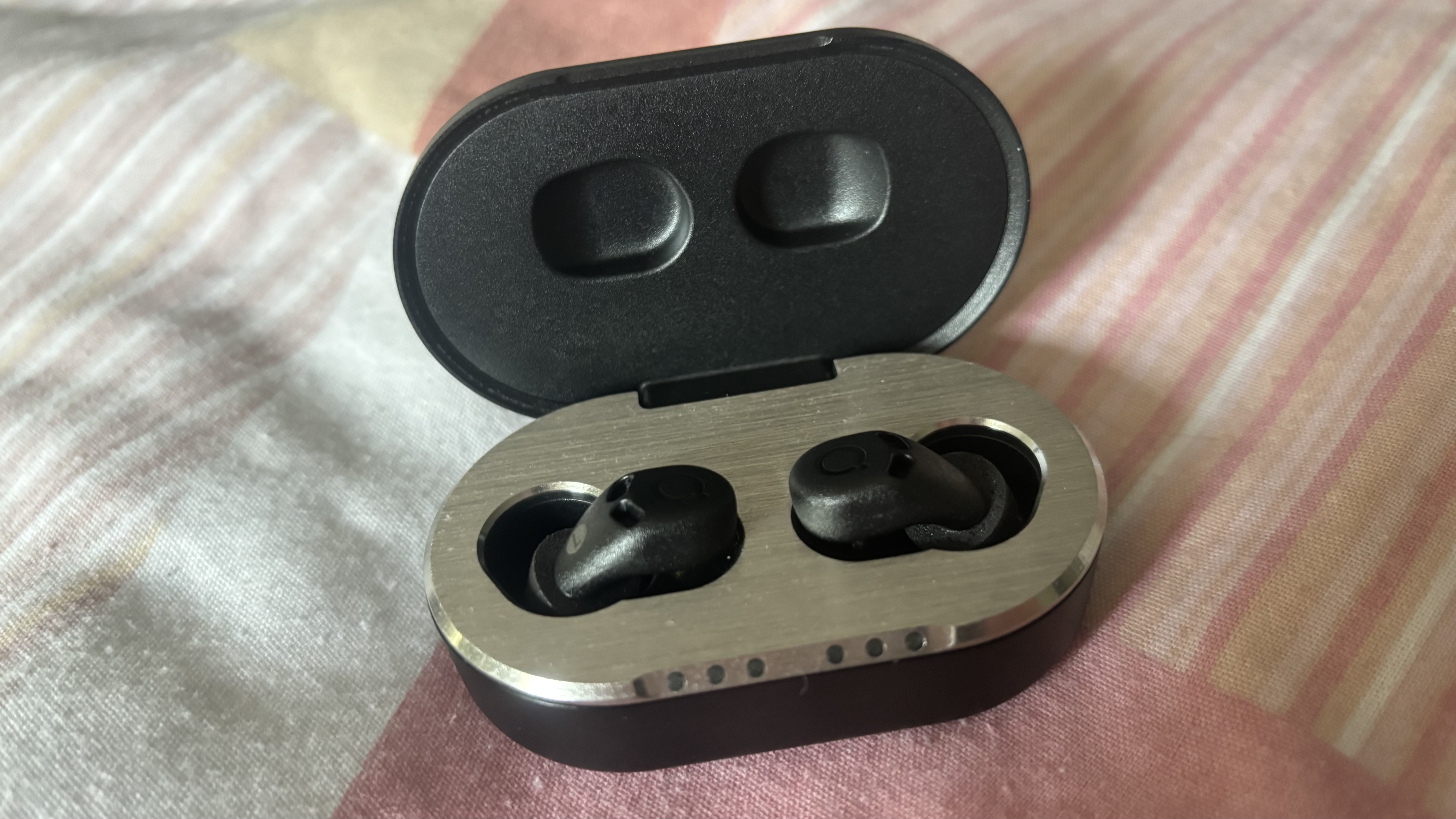The QuietOn 4 Sleep Earbuds in their portable charging case.