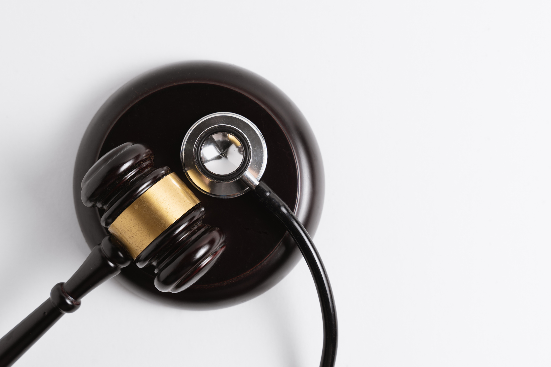 Gavel with Stethoscope on White Background. Law and Healthcare. -