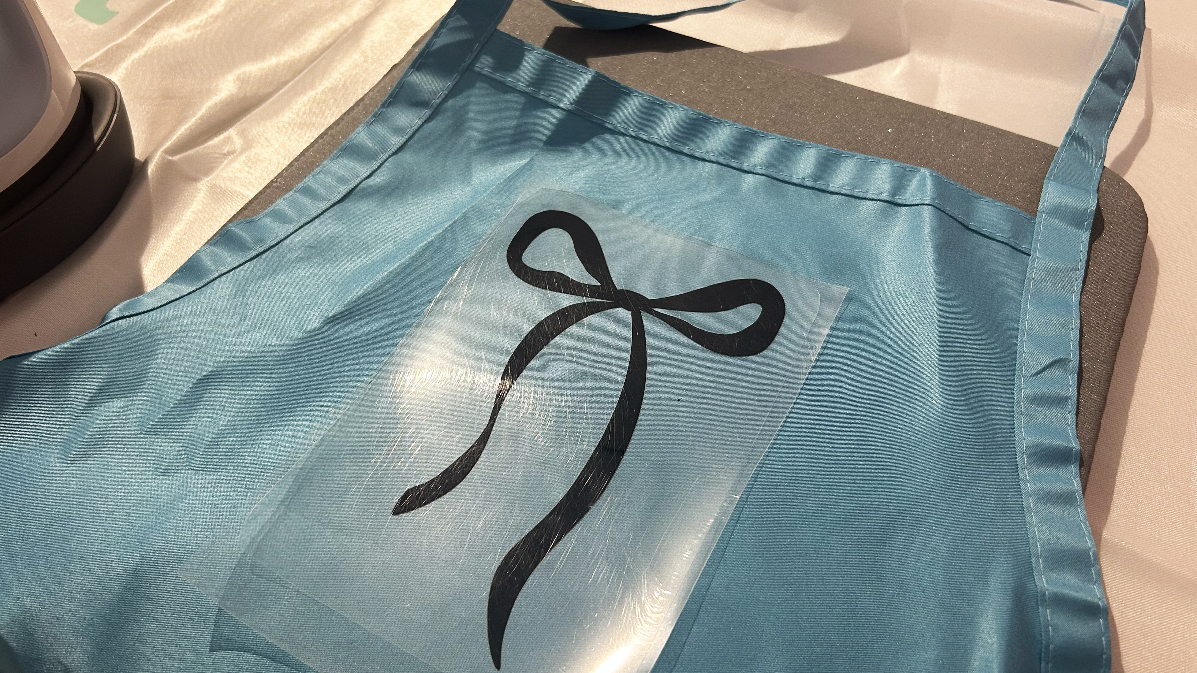 Iron on Bow on blue apron made from Cricut Maker 4