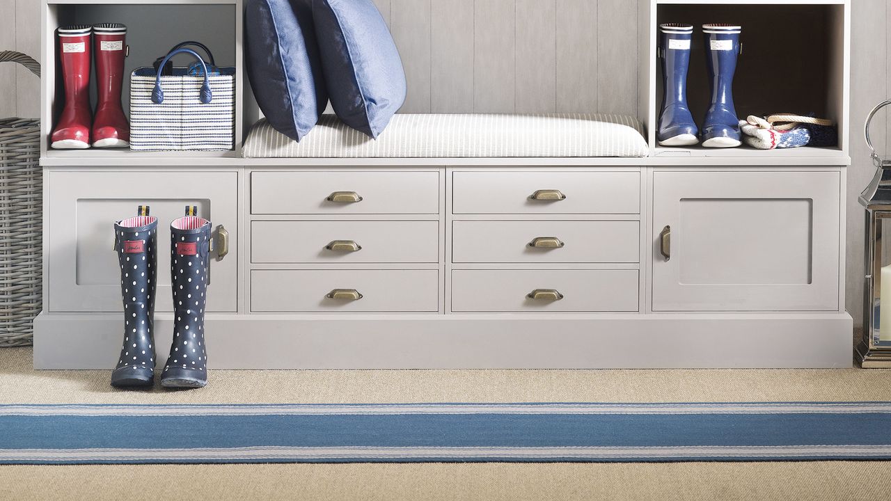 Hallway runner ideas a close up of striped flooring beside a storage unit with wellington boots and cushions