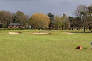 A hole and the clubhouse pictured at Brackenwood Golf Club