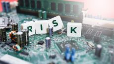 Four tiles spelling out risk on a computer circuit board