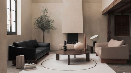 A neutral, modern living room with light, plaster effect walls. A black and a cream leather sofa face one another in the centre, a round dark wood coffee table between them on a large white rectangular rug. A fireplace behind. 