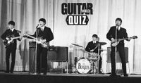 The Beatles perform onstage at the Olympia Theatre in Paris in early 1964