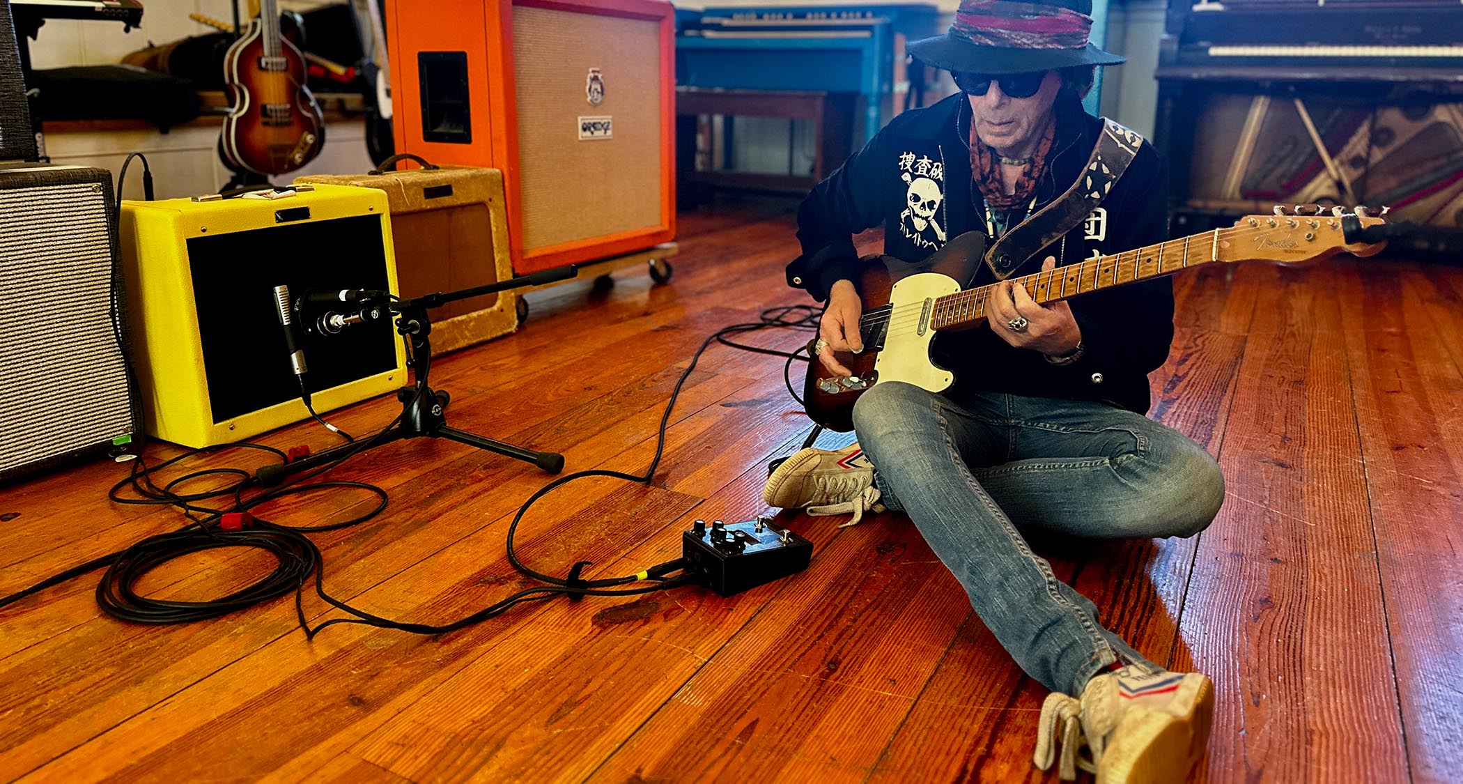 Earl Slick sits on the floor and plays his Telecaster through a Fender combo