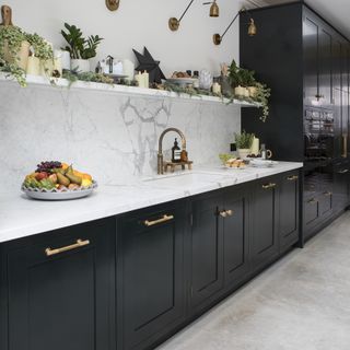 Black kitchen with cupboards and brass handles