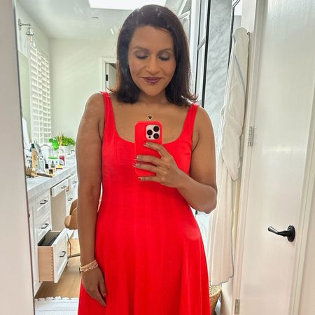 Mindy Kaling takes a mirror selfie wearing a red dress