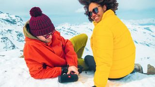 JBL flip Bluetooth speaker and two people in the snow