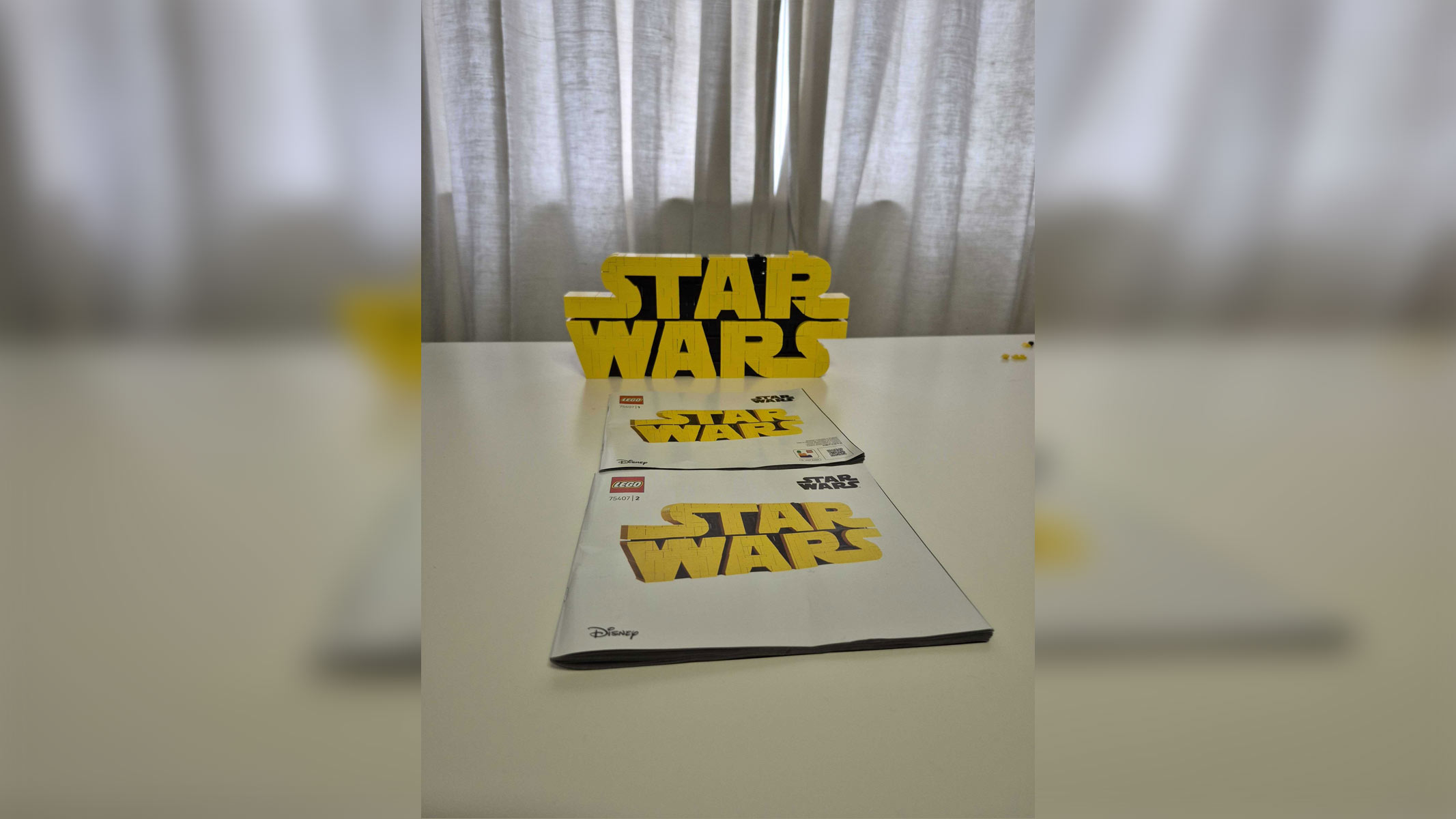 The Completed Lego Star Wars Logo set with two instruction booklets in front of it.
