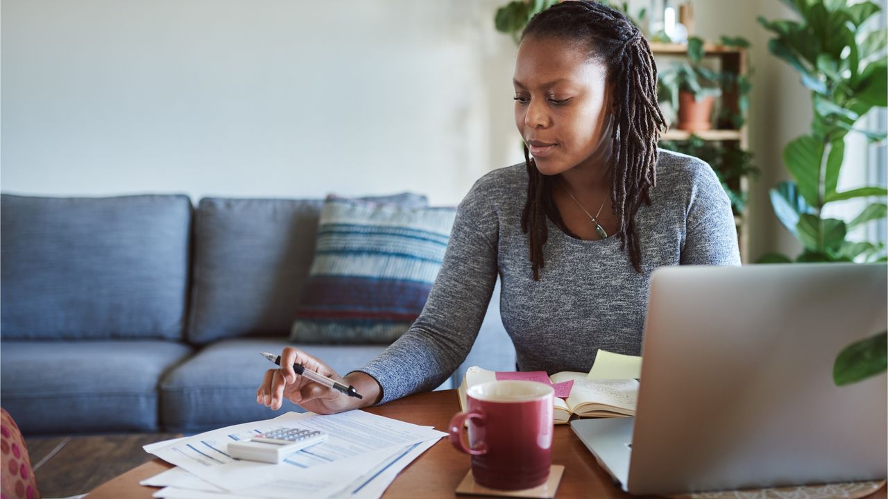 A female investor uses a calculator to figure out the rates of return on her investments.