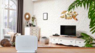 White router on table with TV behind