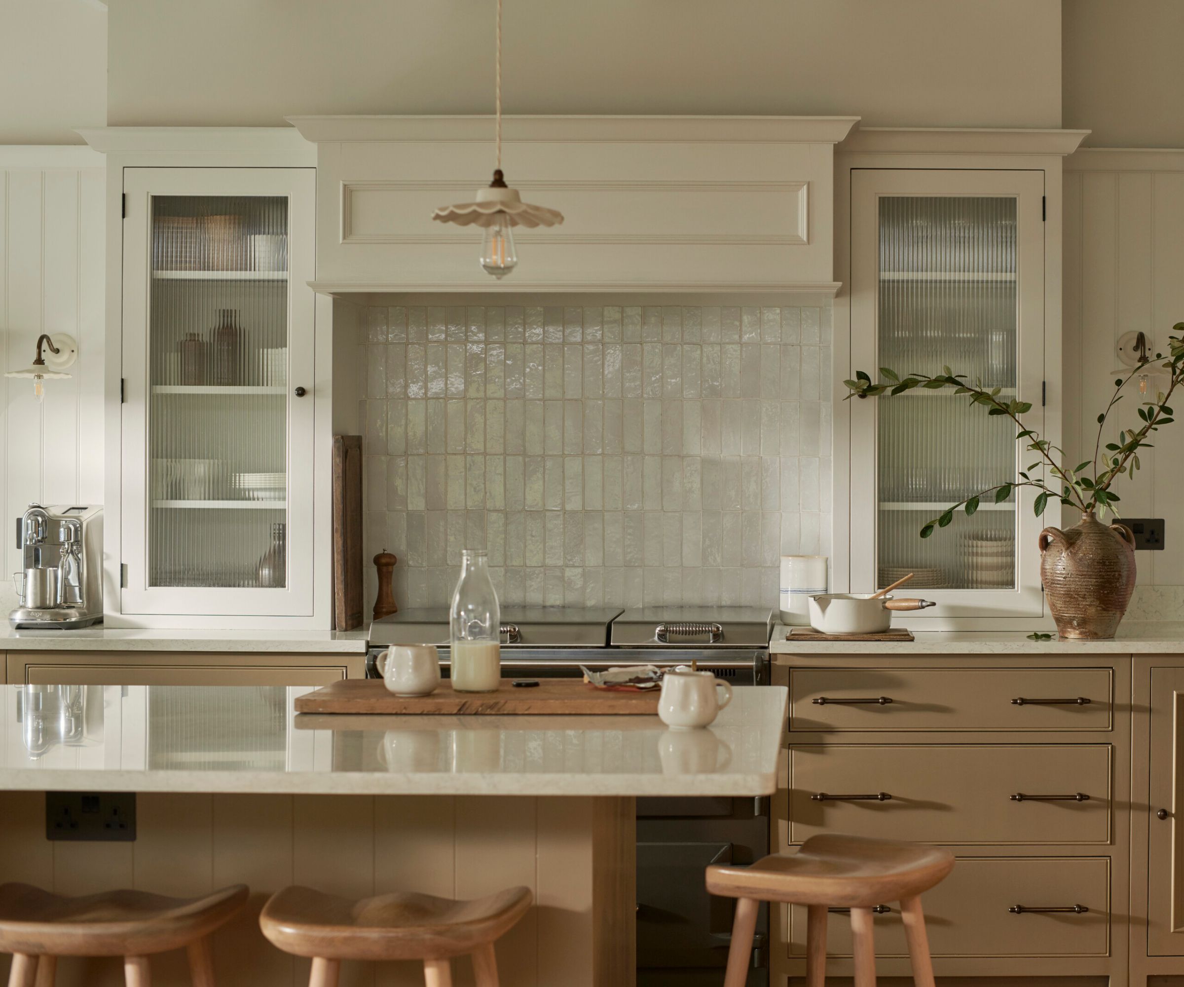 A neutral kitchen with wood cabinets, a custom white range hood, and zellige tiles on the backsplash
