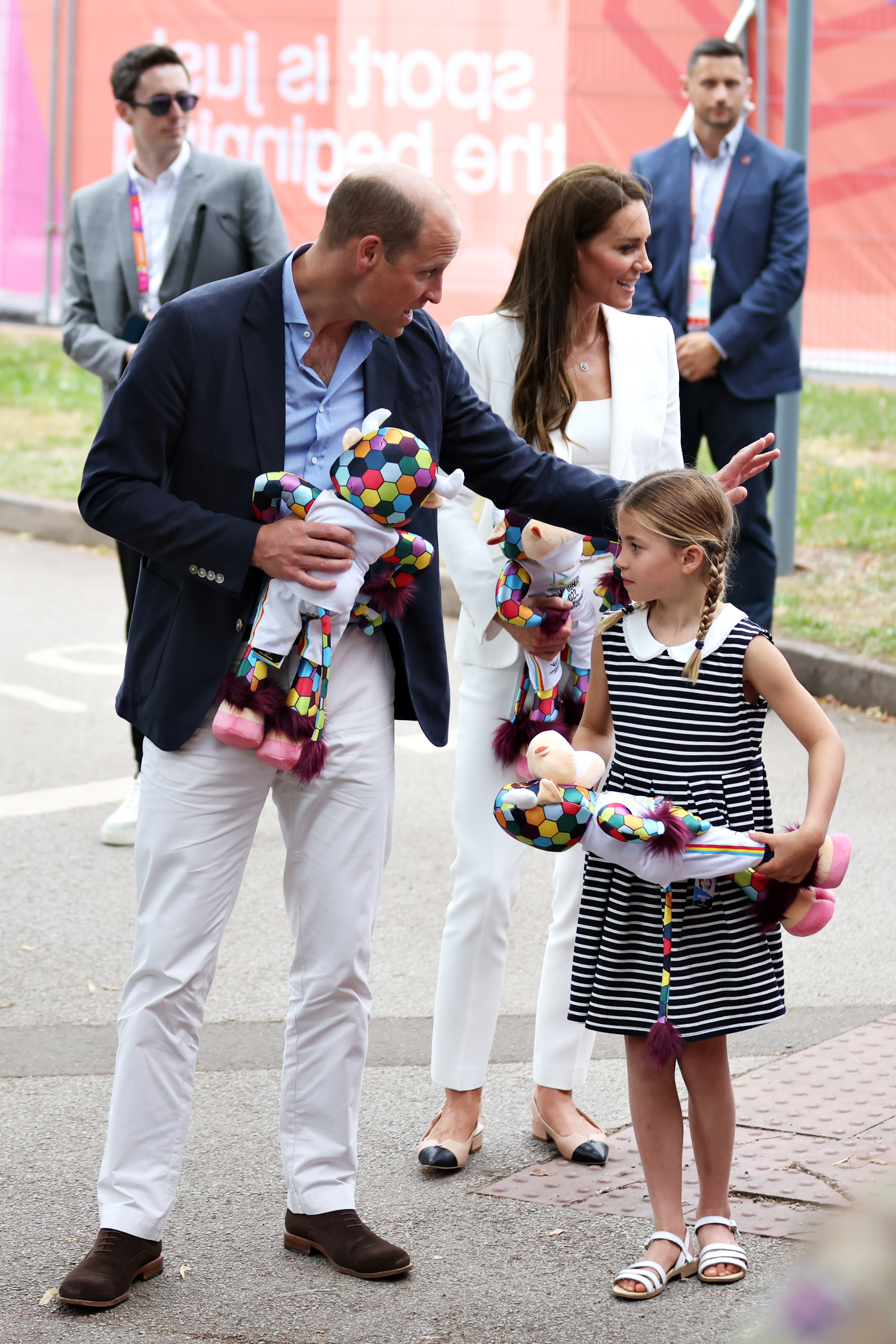 Princess Kate, Prince William, Princess Charlotte walking and holding stuffed animals at the 2022 Commonwealth Games
