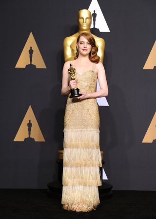 Emma Stone sporting a Givenchy gold fringe gown at the 2017 Oscars.