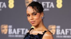 Kerry Washington is pictured with her hair in an updo and wearing a navy dress with flower decals at the 2026 EE BAFTA Film Awards at The Royal Festival Hall on February 22, 2026, in London, England.