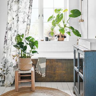 bright bathroom with tub, houseplants and shower curtain