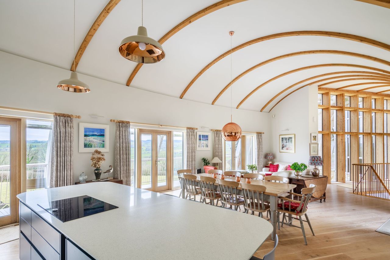 The kitchen diner shows a long room with bifold doors leading onto a balcony