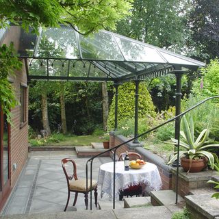 veranda with sloping glass roof tops and garden