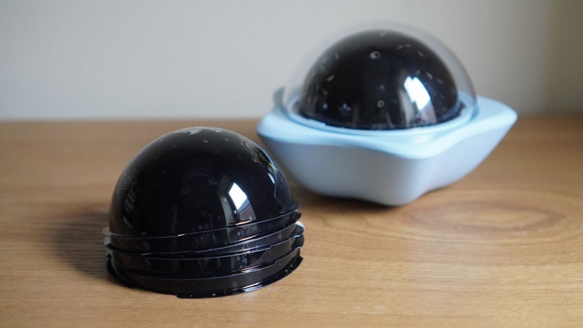 Two dome-shaped items, one on a white star-shaped stand and one not, on a brown wooden surface.