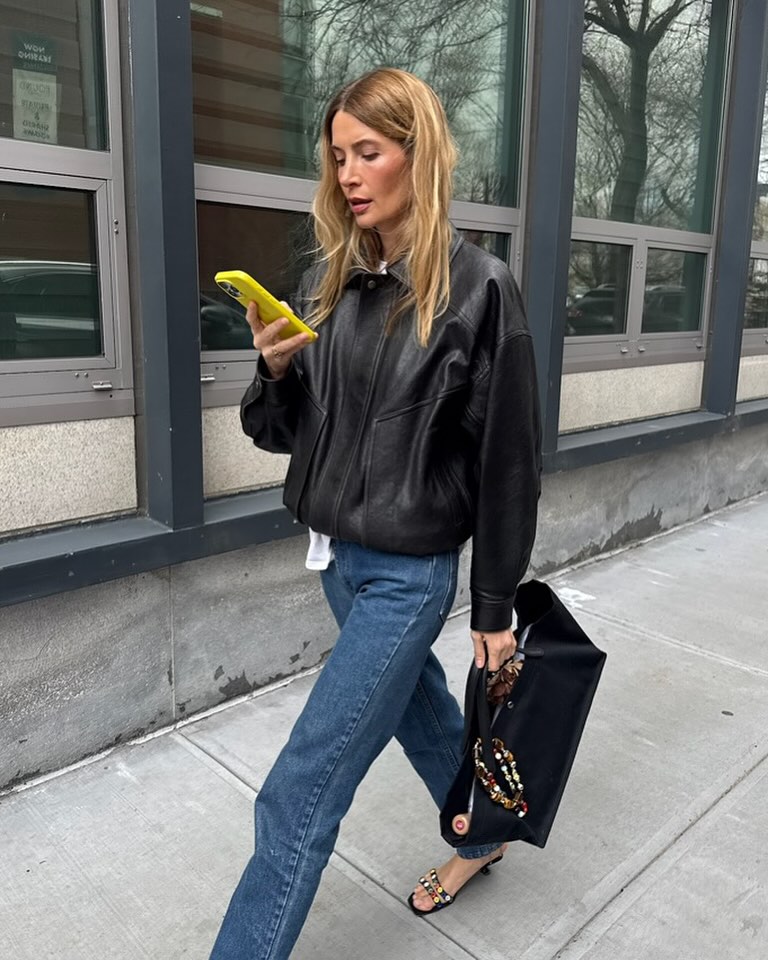 Woman wearing dark wash bootcut jeans fall 2025.