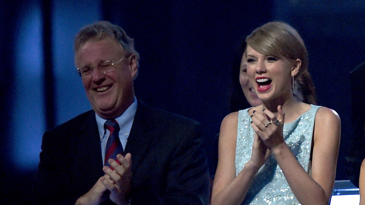 Taylor Swift and her father smiling and clapping at 50th Academy of Country Music Awards