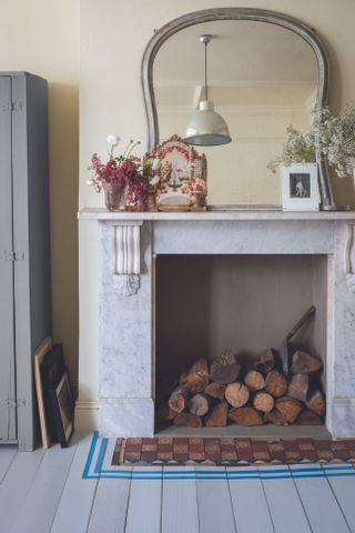 Fireplace with painted floorboards in front by Farrow & Ball
