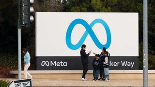 People pose for photos in front of the logo of Facebook parent company Meta on November 9, 2022 in Menlo Park, California. Meta will lay off more than 11,000 staff, the company said on Wednesday. 