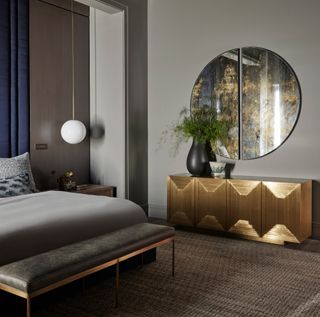 Bedroom with warm grey walls and gold sideboard