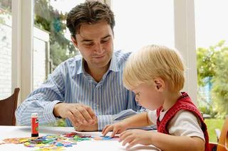 A dad helping his child with drawing and craft