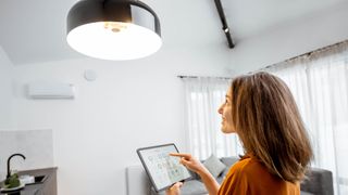 A woman controlling a smart light from her tablet