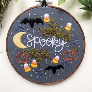 halloween embroidery with a bat, pumpkins and the moon on a grey background
