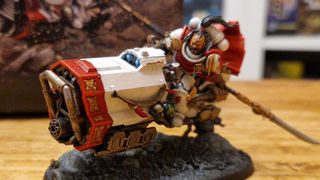 A white-armored Space Marine model on a jet bike