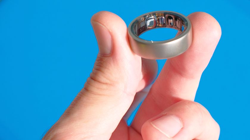 A close up of the Amazfit Helio Ring on a user&#039;s finger against a colorful background