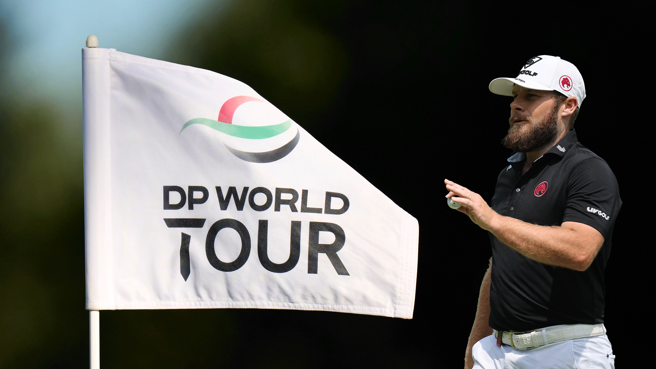 A DP World Tour pin flag and Tyrrell Hatton (right) acknowledging the crowd