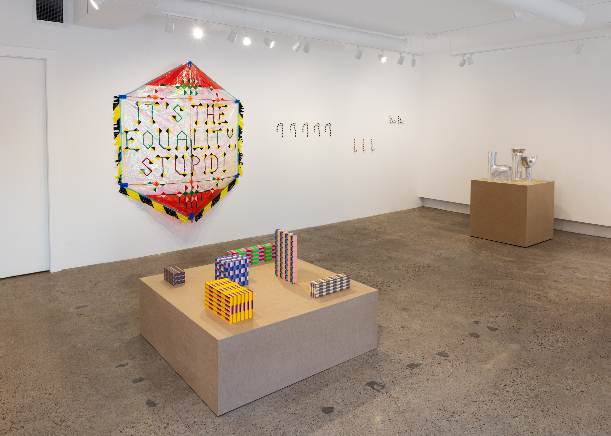 exhibition space with brighly coloured tape-wrapped objects