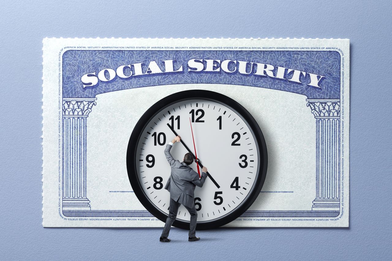 Man Holding Back Hands Of Time In Front Of Social Security Card