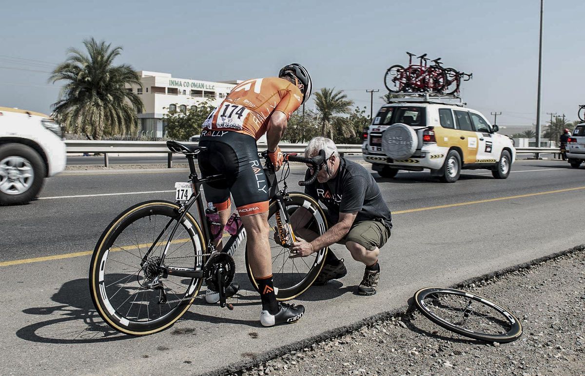 Tim Sparks puts his mechanic skills to work on Brad Huff's trashed wheel.