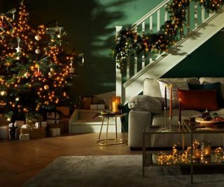 A Christmas tree in a room with a sofa and a staircase. LED lights all around.