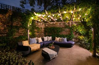 corner sofa with pergola covered in festoon lights for outdoor lighting ideas