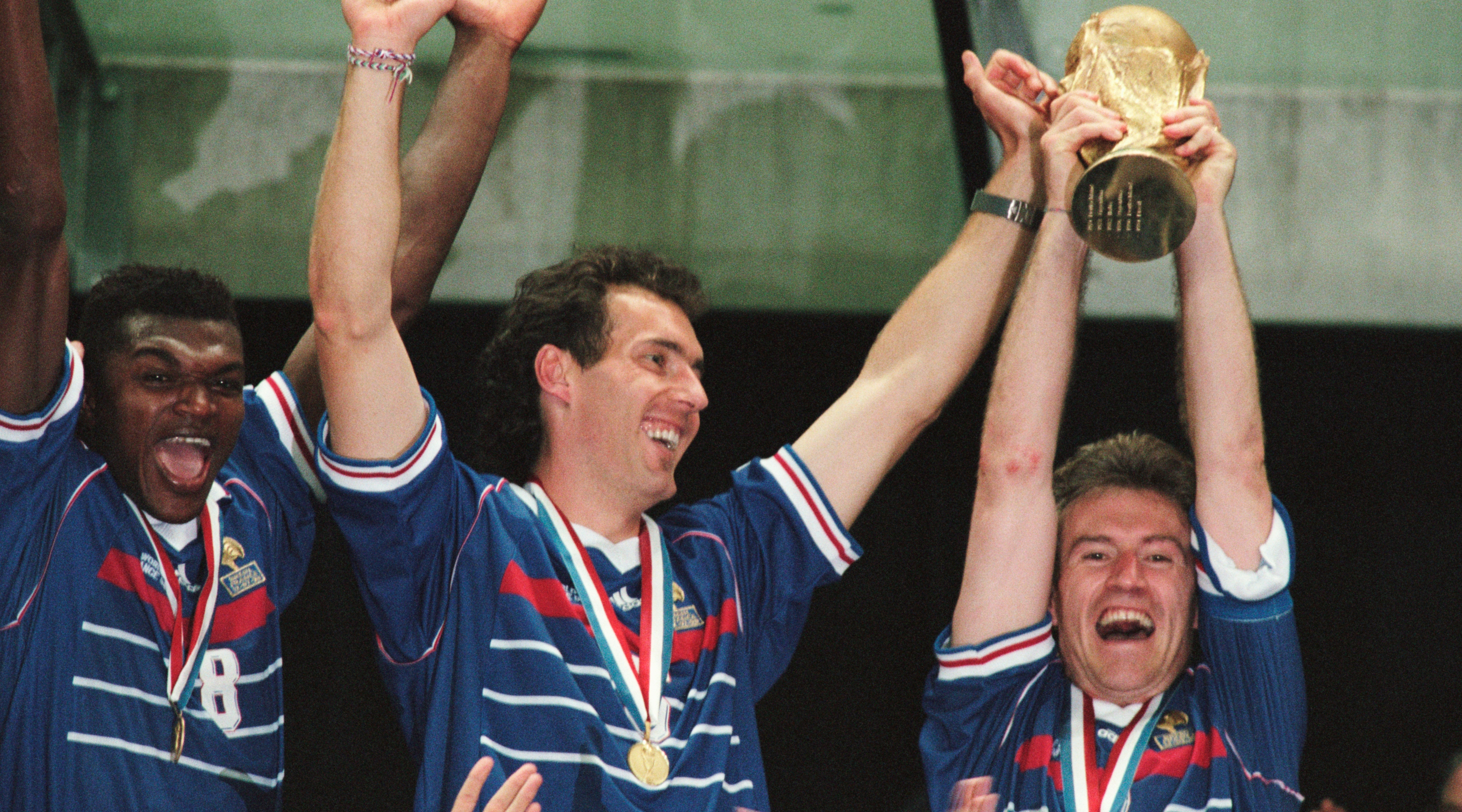 France's players (L-R) Marcel Desailly, Laurent Blanc and captain Didier Deschamps, holding the trophy, celebrate after their 3-0 victory over Brazil in the final of the 1998 FIFA World Cup. | Location: Saint-Denis, France.