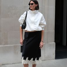 Woman in white Uniqlo jacket and black silk skirt