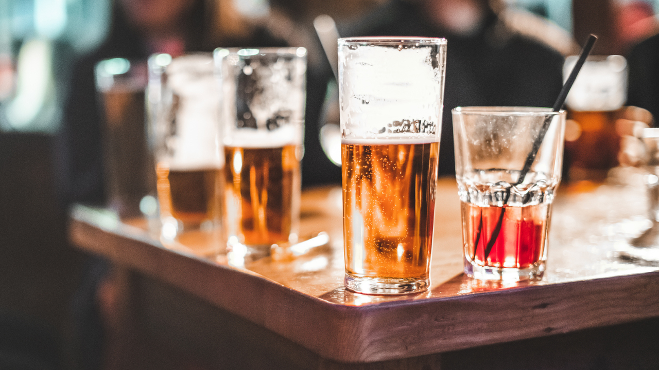 Pint glasses lined up on a bar