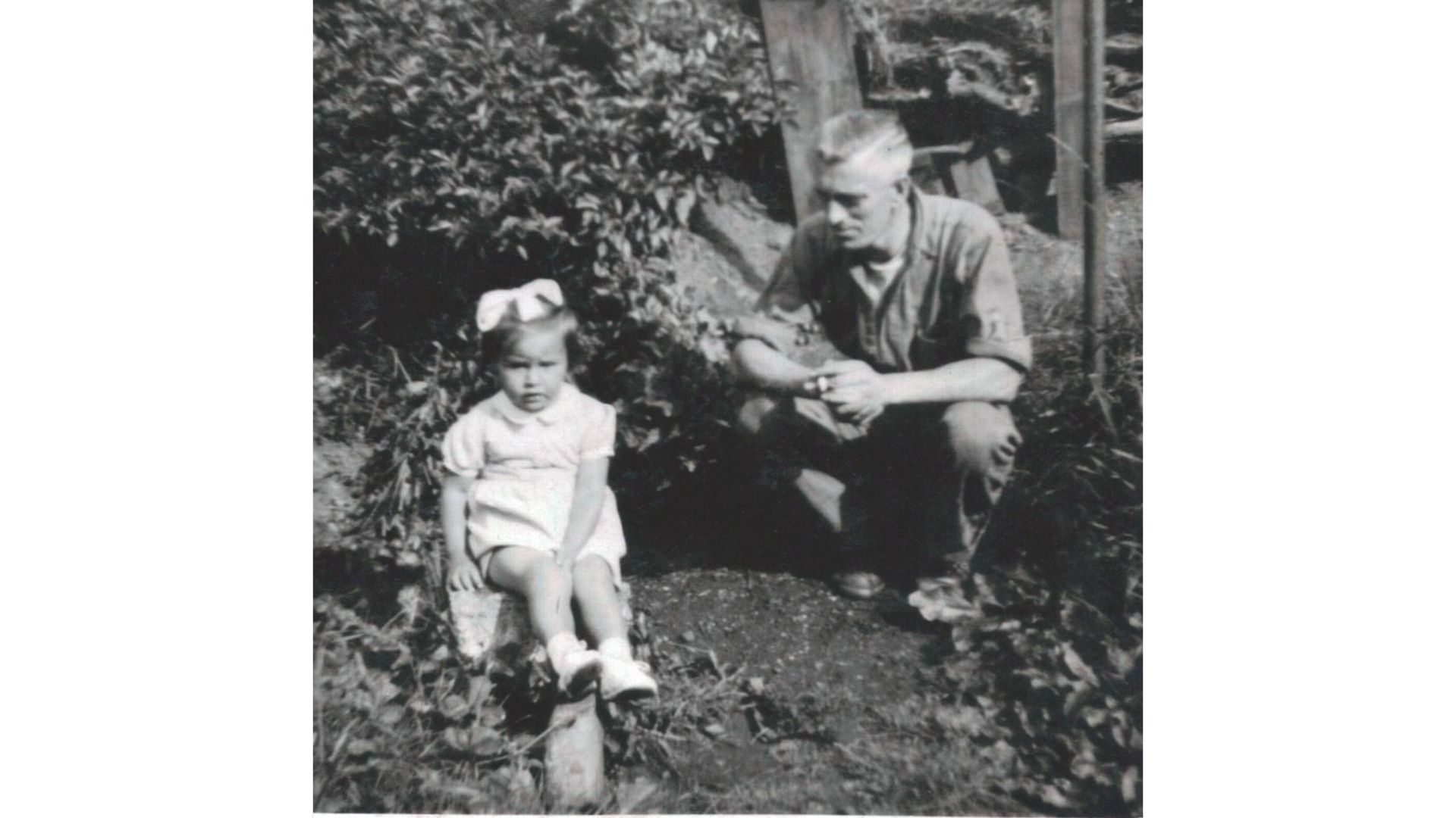 Helen Edwards aged 2 sitting in a garden with stepdad Tommy