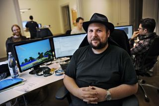 Une photo du créateur de Minecraft, Markus Persson, assis à son bureau